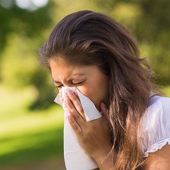 lady sneezing into a tissue